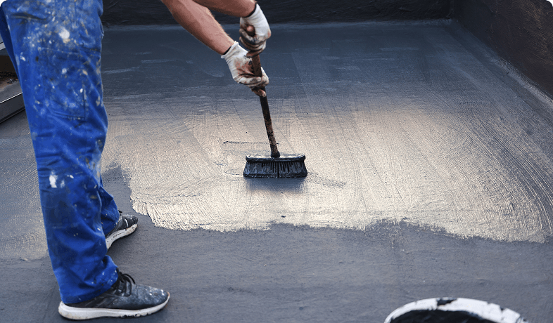 Roofer spreading protective coating