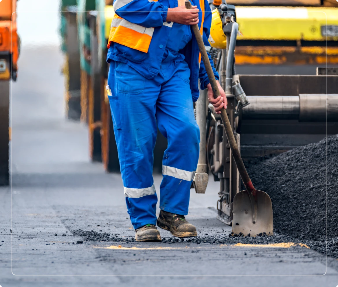 Laborer in blue uniform with shovel